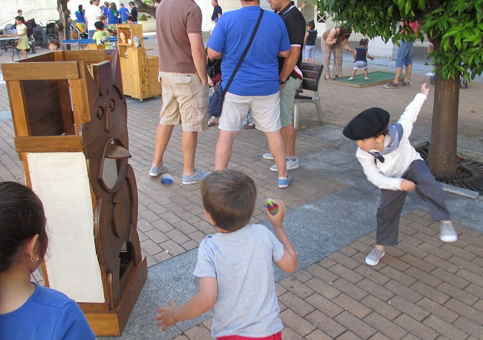 Niños jugando a lanzar bolas a una diana de madera durante las fiestas de San Juan en Leioa (23/06/2015)