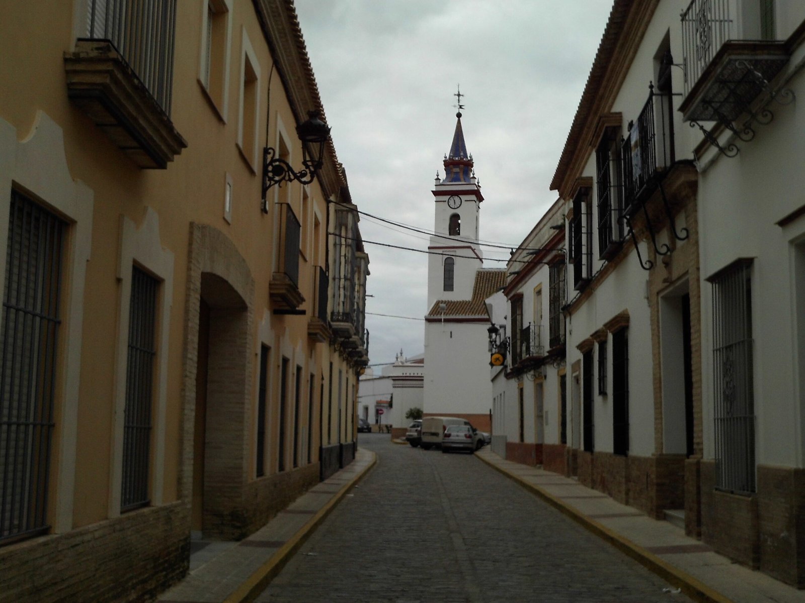 Calle de Villanueva del Ariscal con la iglesia de Santa María de las Nieves al fondo