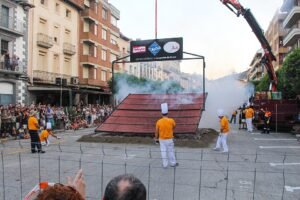 Participantes ante una gran parrilla de longaniza en una plaza de Graus durante la edición de 2023