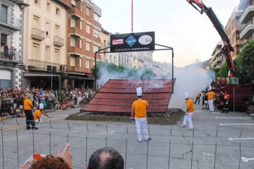 Participantes ante una gran parrilla de longaniza en una plaza de Graus durante la edición de 2023